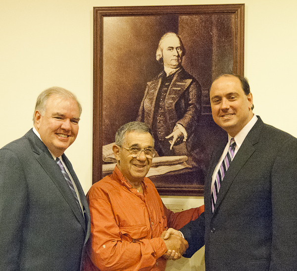 Under a portrait of John Adams, 2nd President of the US and a framer of the Declaration of Independence, Halberstadt (center) thanks Chairman Kevin Honan (left) and Chairman Jamie Eldridge (right) for their support and vision.